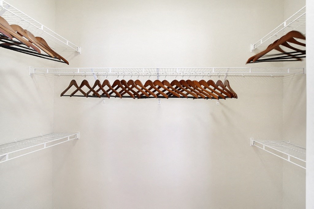 a walk in closet with white shelves and a white wall at Faulkner Flats Apartment Homes, Mississippi, 38655