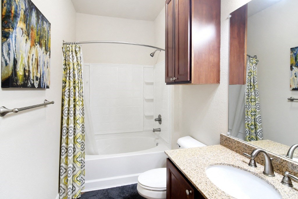 a bathroom with a sink toilet and bathtub at Faulkner Flats Apartment Homes, Oxford