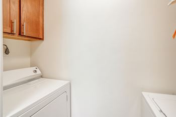 a washer and dryer in a laundry room with white walls at Cambridge Station Apartment Homes in Oxford, MS