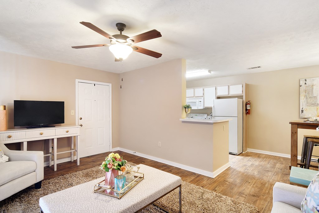 a living room with a ceiling fan    and a kitchen at Parklane Apartment Homes, McComb