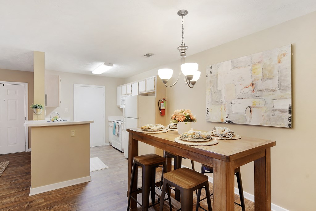 a kitchen and dining room with a wooden table and chairs at Parklane Apartment Homes, McComb