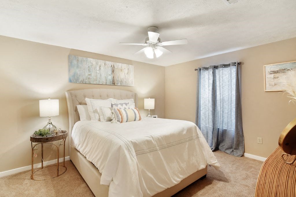 a bedroom with a bed and a ceiling fan  at Parklane Apartment Homes, Mississippi