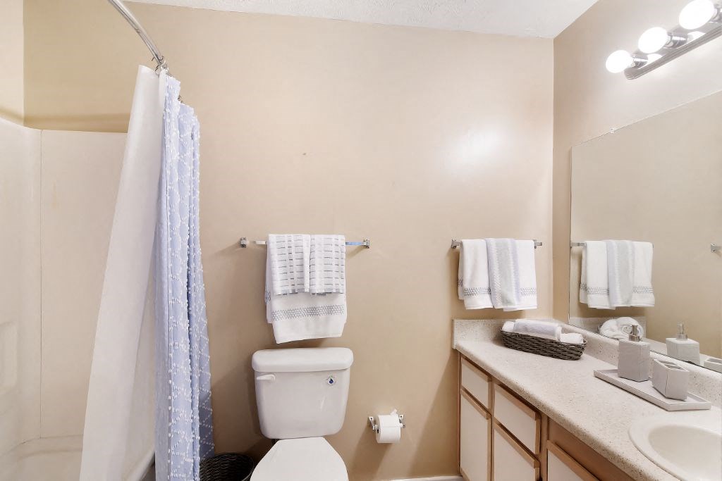 a bathroom with a toilet sink and shower  at Parklane Apartment Homes, Mississippi, 39648