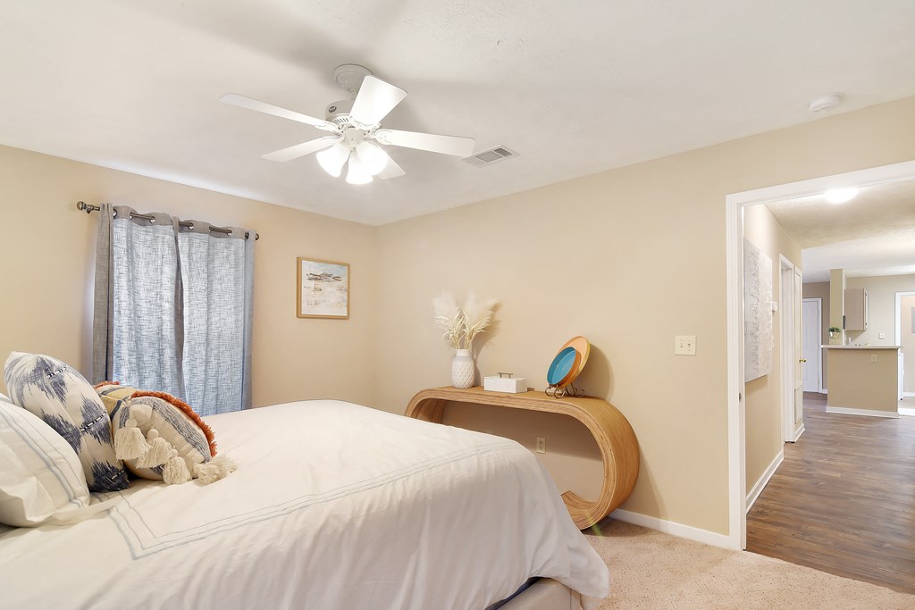 a bedroom with a large bed and a ceiling fan at Parklane Apartment Homes, Mississippi