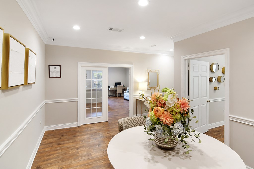a dining room with a table and a vase with flowers at Parklane Apartment Homes, Mississippi, 39648