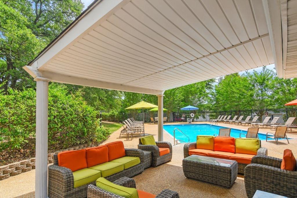 a patio with couches and a pool in the background  at Parklane Apartment Homes, Mississippi