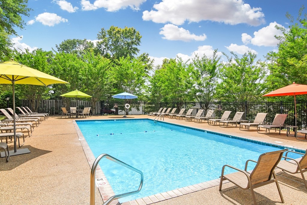 our resort style pool is filled with chairs and umbrellas at Parklane Apartment Homes, Mississippi