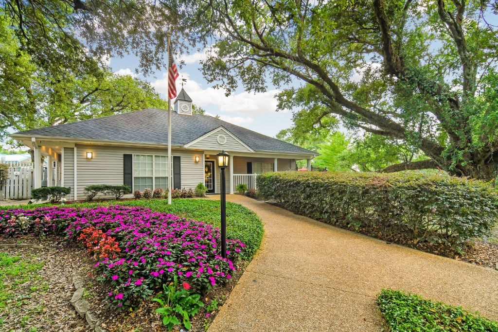 a house with a flag on a pole in front of it  at Parklane Apartment Homes, McComb, Mississippi