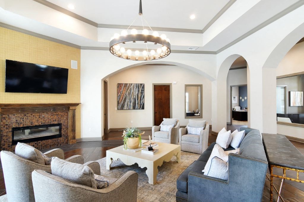 a living room with a fireplace and a chandelier at Audubon Park Apartment Homes, Louisiana, 70791