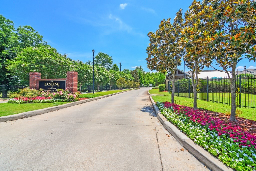 a street with a sign that reads laurelwood in front of a fence with trees and  at Landing at Willow Bayou Apartment Homes, Bossier City, LA, 71111