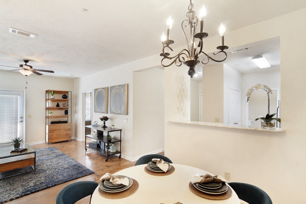 a dining room with a table and chairs and a chandelier  at Landing at Willow Bayou Apartment Homes, Bossier City