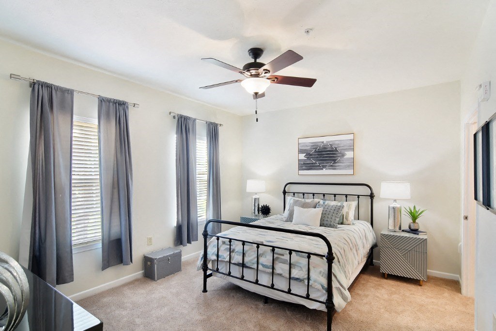 a bedroom with a bed and a ceiling fan  at Landing at Willow Bayou Apartment Homes, Louisiana