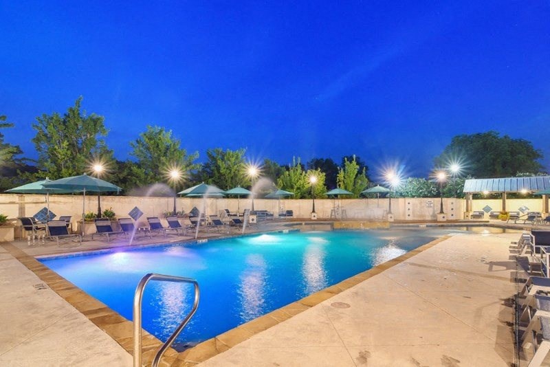 a resort style swimming pool with chaise lounge chairs and umbrellas  at Landing at Willow Bayou Apartment Homes, Bossier City, LA, 71111