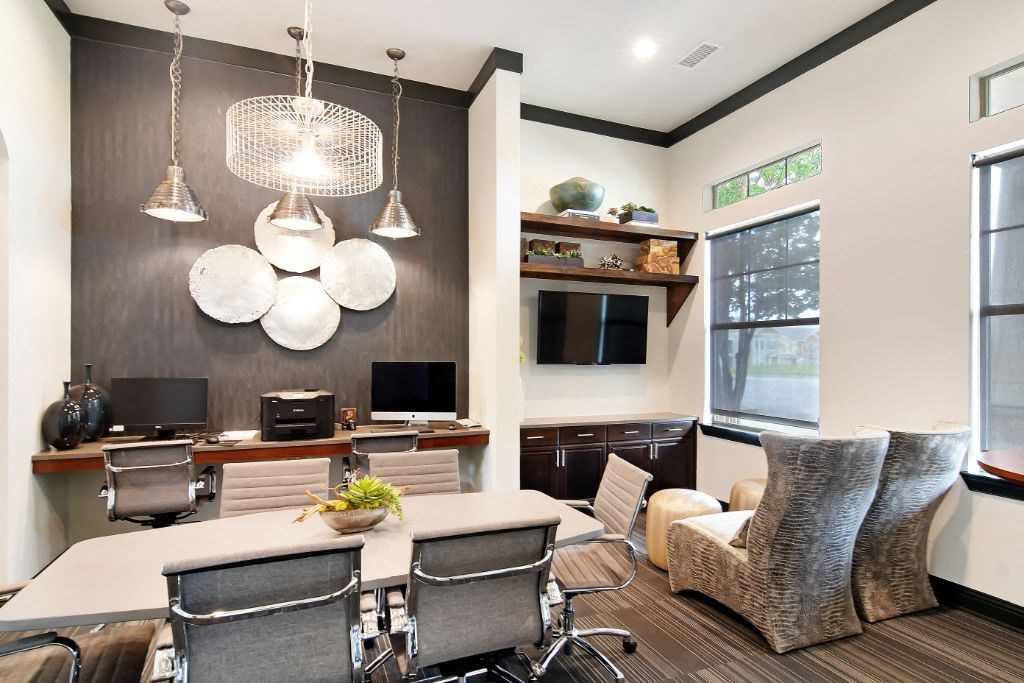a conference room with a table and chairs and a tv in the corner of the room  at Wellington Grande Apartment Homes, Longview