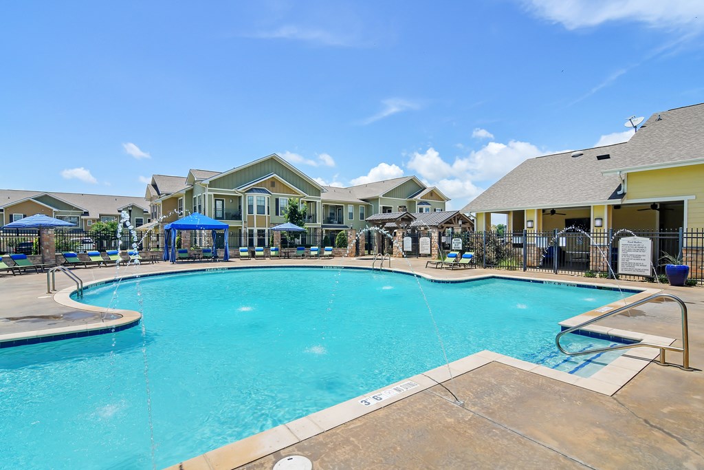 Swimming Pool Area With Shaded Chairs at Wellington Grande Apartment Homes, Longview, TX, 75605