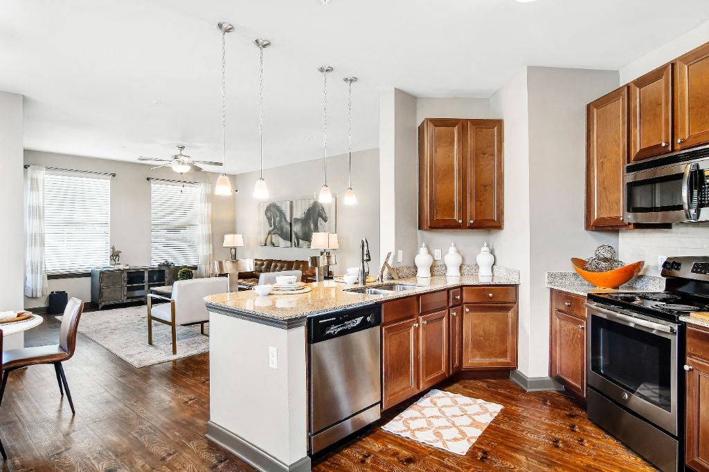 an open kitchen and living room with a couch in the background  at Wellington Grande Apartment Homes, Longview, TX