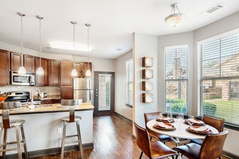 a kitchen and dining room with a table and chairs  at Wellington Grande Apartment Homes, Longview