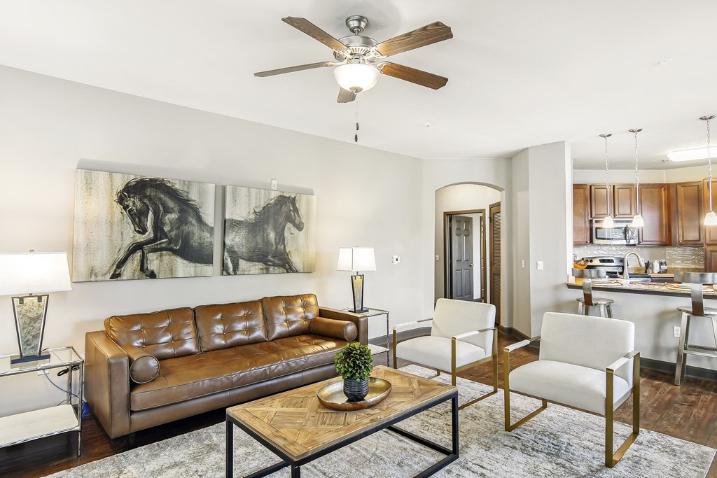 a living room with a ceiling fan and a couch at Wellington Grande Apartment Homes, Longview, Texas