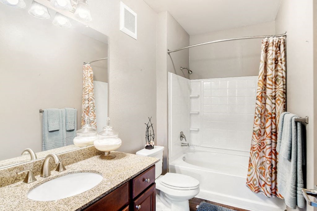 a bathroom with a sink toilet and shower  at Wellington Grande Apartment Homes, Longview