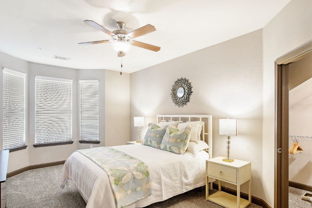 a bedroom with a bed and a ceiling fan  at Wellington Grande Apartment Homes, Longview, Texas