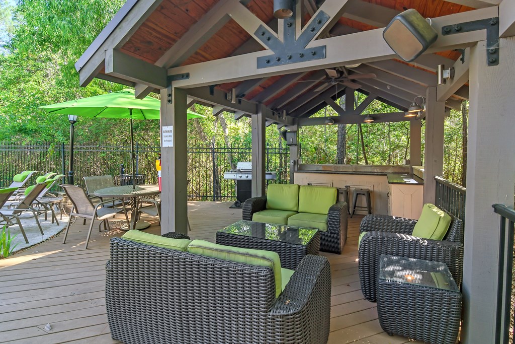 a covered patio with wicker furniture and a grill at Lagniappe of Biloxi Apartment Homes, Biloxi, MS, Mississippi