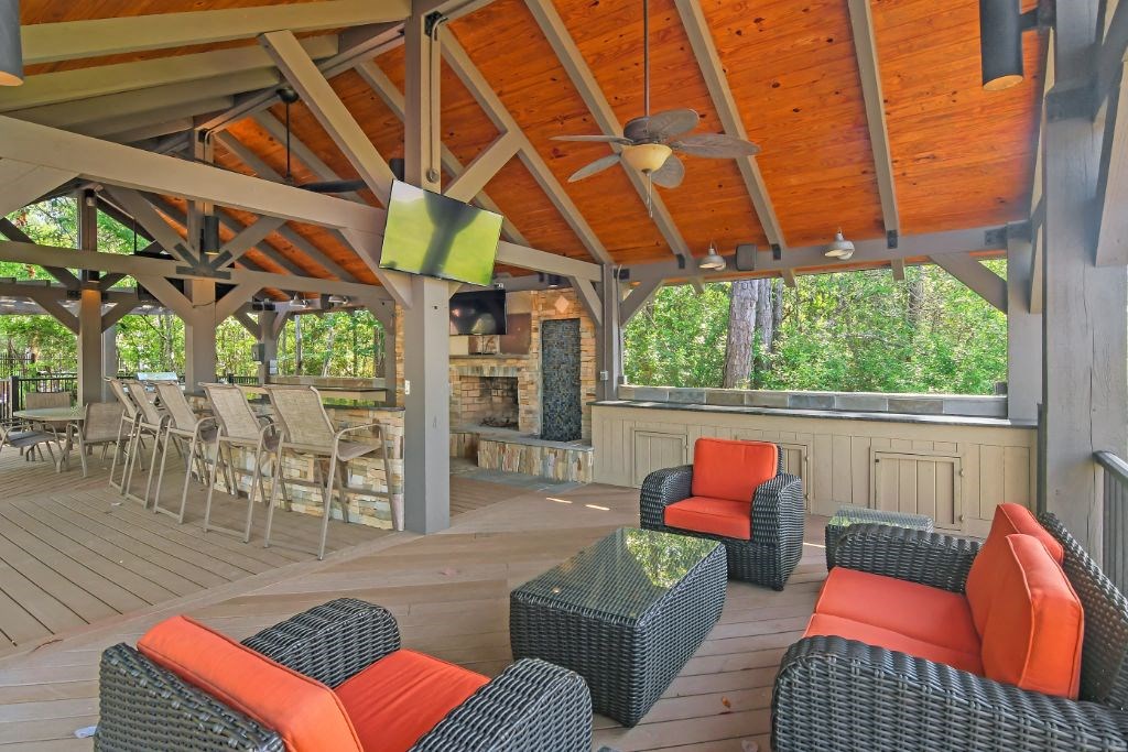 a screened in porch with furniture and a fireplace  at Lagniappe of Biloxi Apartment Homes, Mississippi, 39532