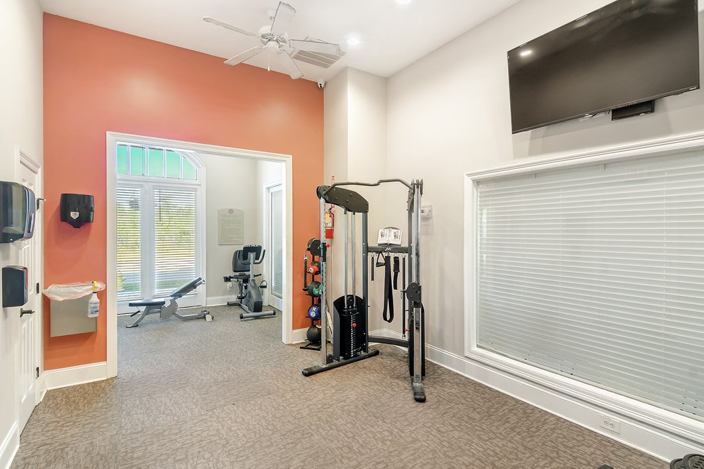 a home gym with exercise equipment and a tv at Lagniappe of Biloxi Apartment Homes, Biloxi, MS, 39532