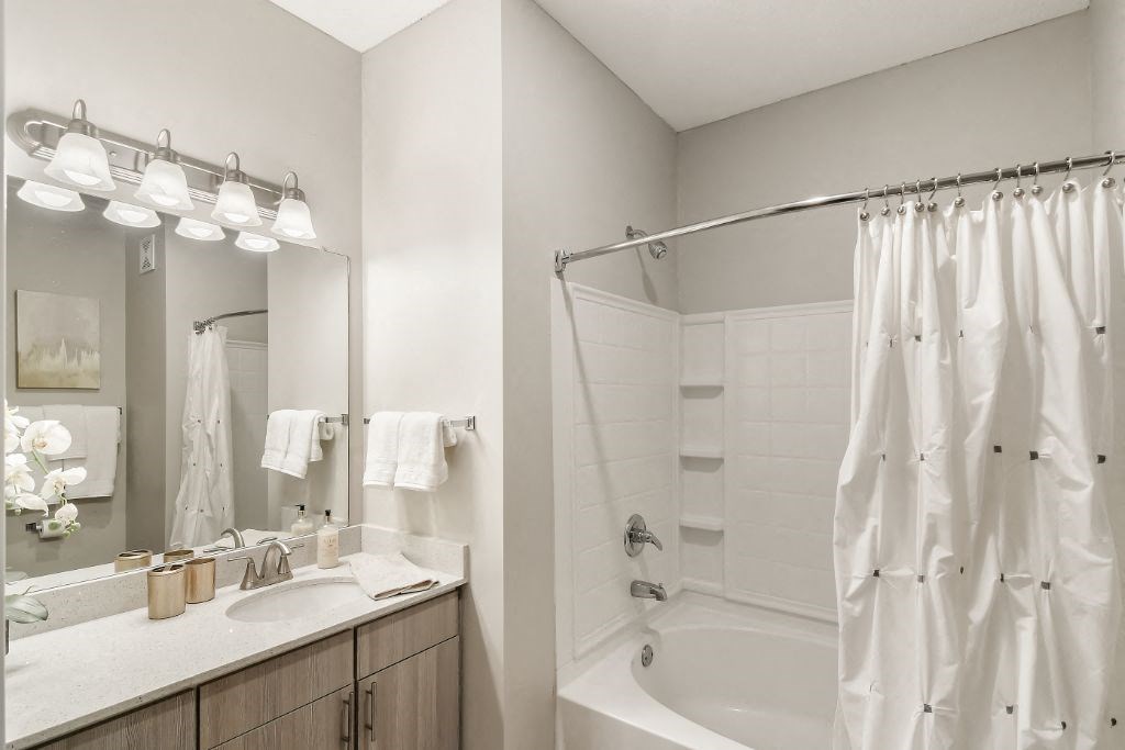 a bathroom with a bathtub and a sink  at Lagniappe of Biloxi Apartment Homes, Biloxi, MS