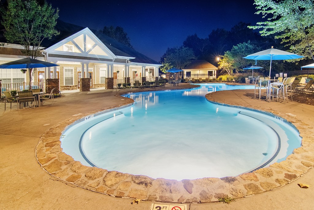 Cool pool with chairs and umbrellas at night at the resort at Highlands Apartment Homes, Tennessee