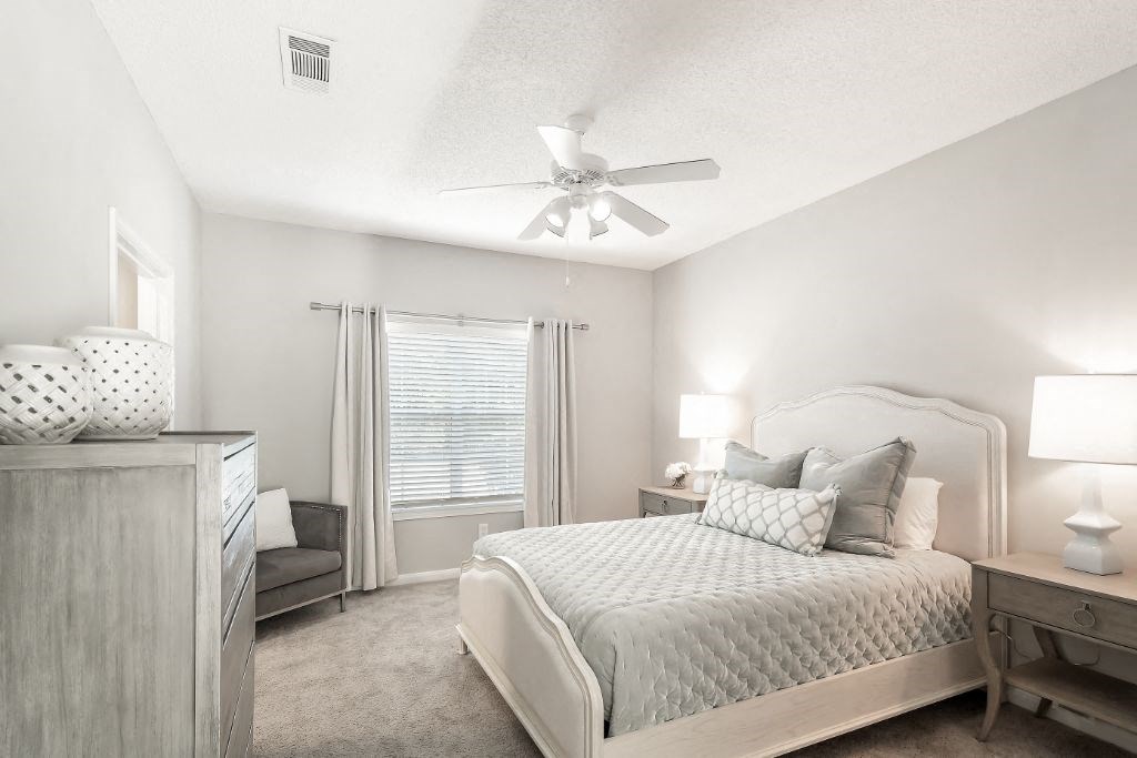 a bedroom with a bed and a ceiling fan  at Lagniappe of Biloxi Apartment Homes, Biloxi, Mississippi
