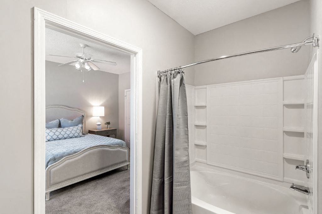 a bedroom with a bed and a bathtub  at Lagniappe of Biloxi Apartment Homes, Mississippi