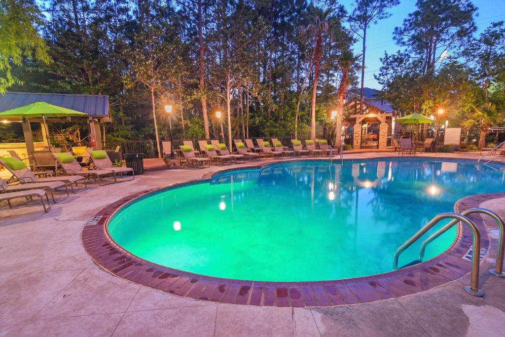 a resort style pool with lounge chairs and a gazebo  at Lagniappe of Biloxi Apartment Homes, Mississippi