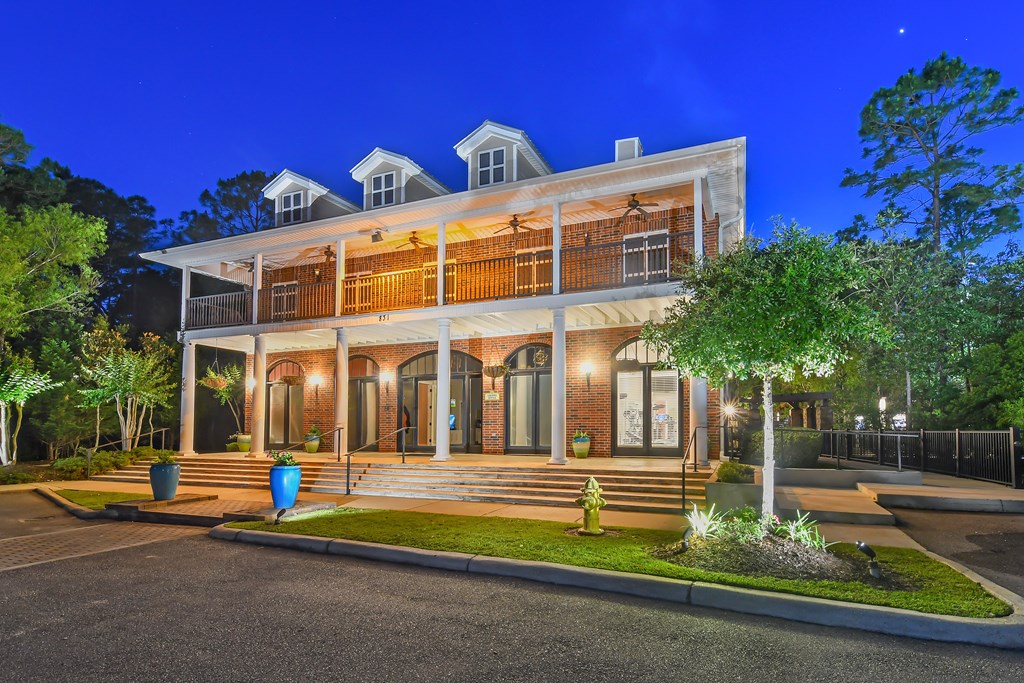 a house with a large porch and a tree in front of it at Lagniappe of Biloxi Apartment Homes, Mississippi