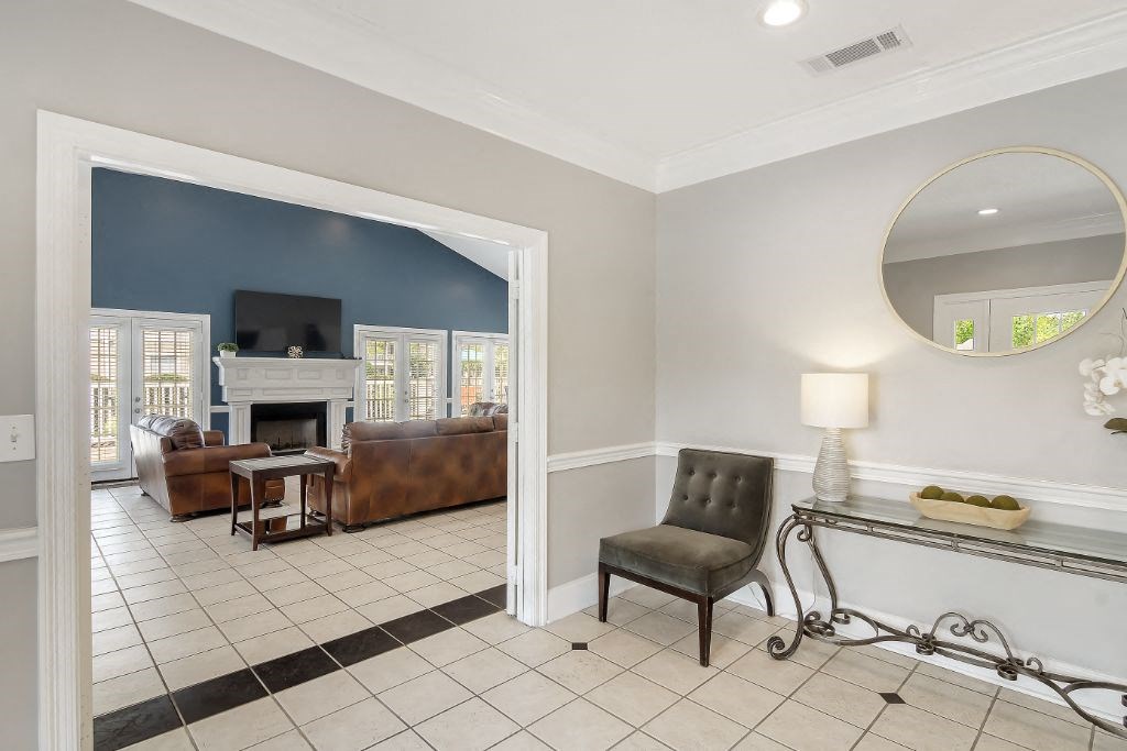 a living room with a fireplace and a mirror on the wall  at The Pointe Apartment Homes, Gautier, MS