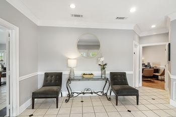 a living room with two black chairs and a glass tableat The Pointe Apartment Homes, Gautier, MS