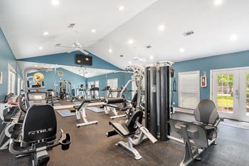 a gym with cardio machines and weights on the floorat The Pointe Apartment Homes, Gautier, MS