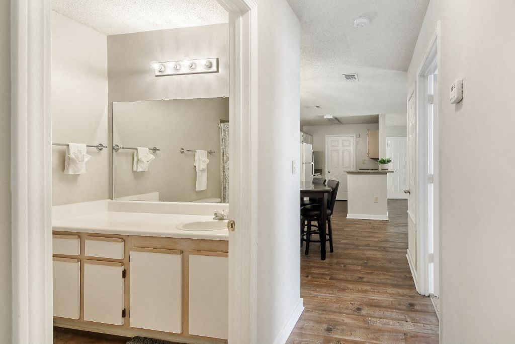a bathroom with a bathtub and a sink  at The Pointe Apartment Homes, Gautier, MS