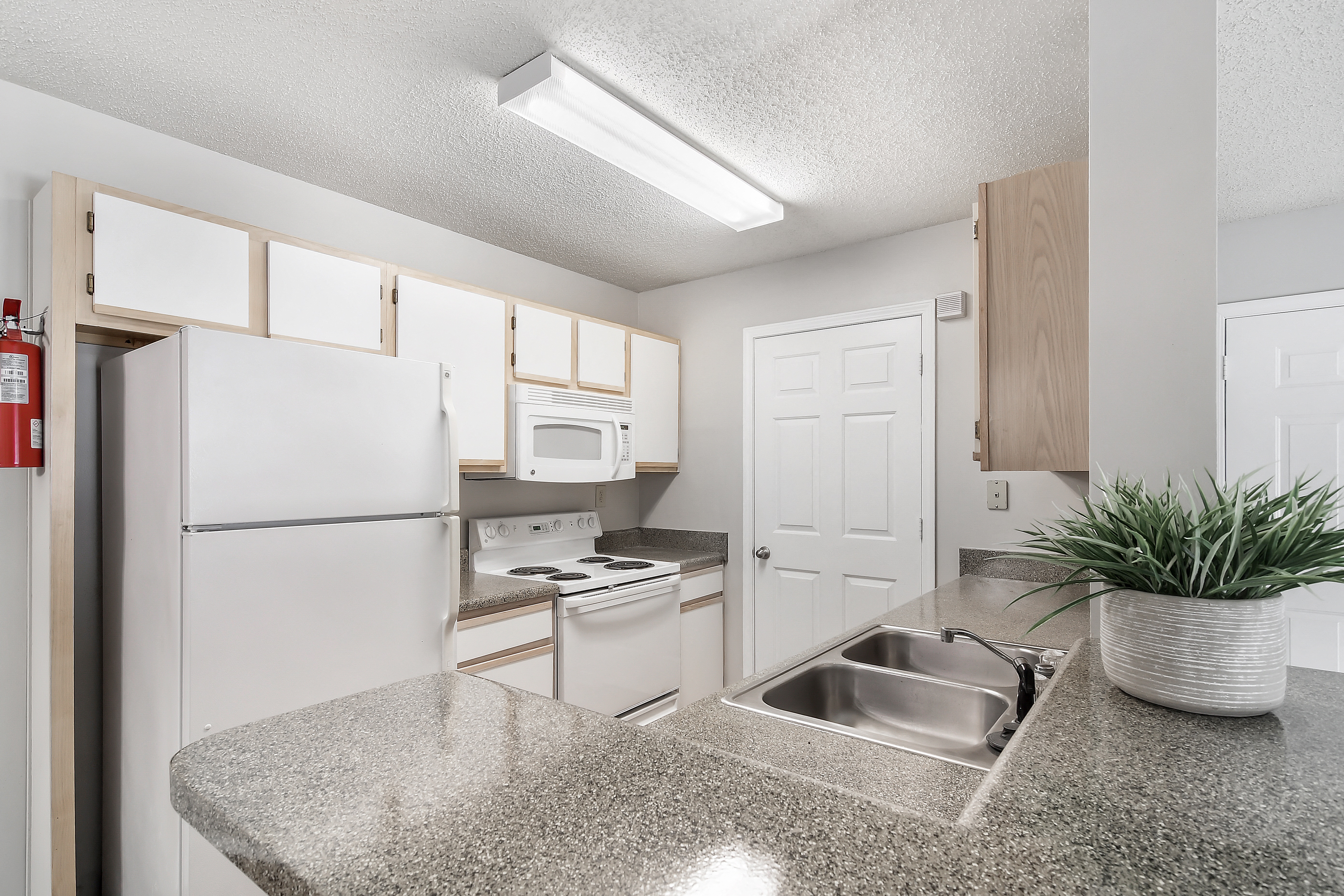a kitchen with white appliances and a granite counter top