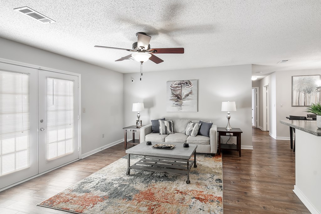 a living room with a couch and a ceiling fan at The Pointe Apartment Homes in Gautier, MS 