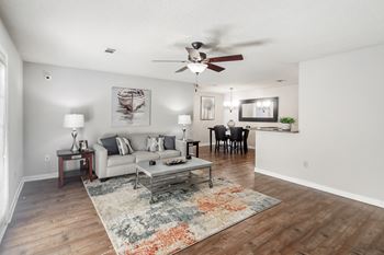 a living room with hardwood floors, a couch and a ceiling fanat The Pointe Apartment Homes, Gautier, 39553