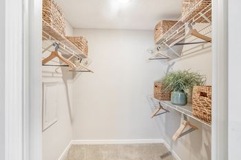 the walk in closet of a home with baskets and hangers on the wall at Reserve of Jackson Apartment Homes, Mississippi, 39211
