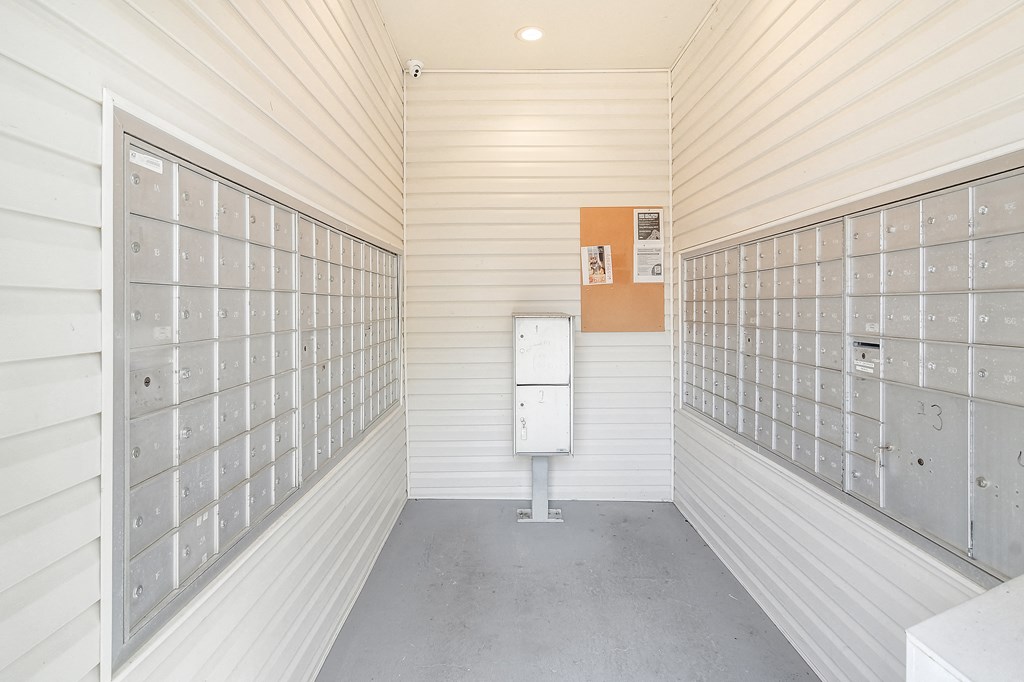 the mail room of a white building with mailboxes on the wall at Reserve of Jackson Apartment Homes, Mississippi, 39211