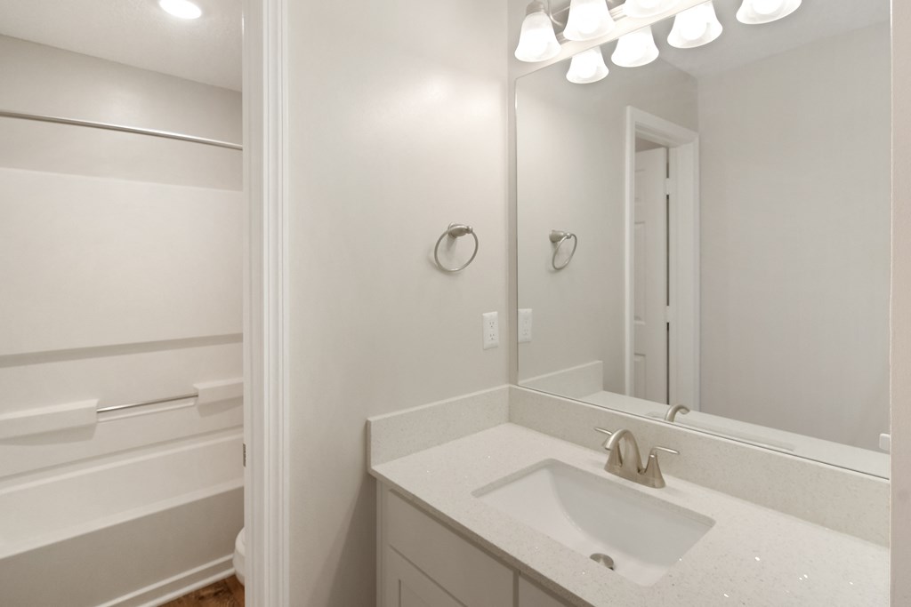 an empty bathroom with a sink and a mirror at The Woodlands Apartment Homes, Mississippi