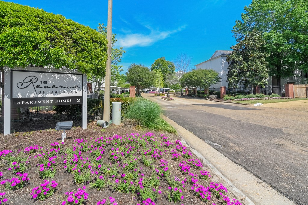 a street with a sign and flowers on the side of a road at Reserve of Jackson Apartment Homes, Mississippi