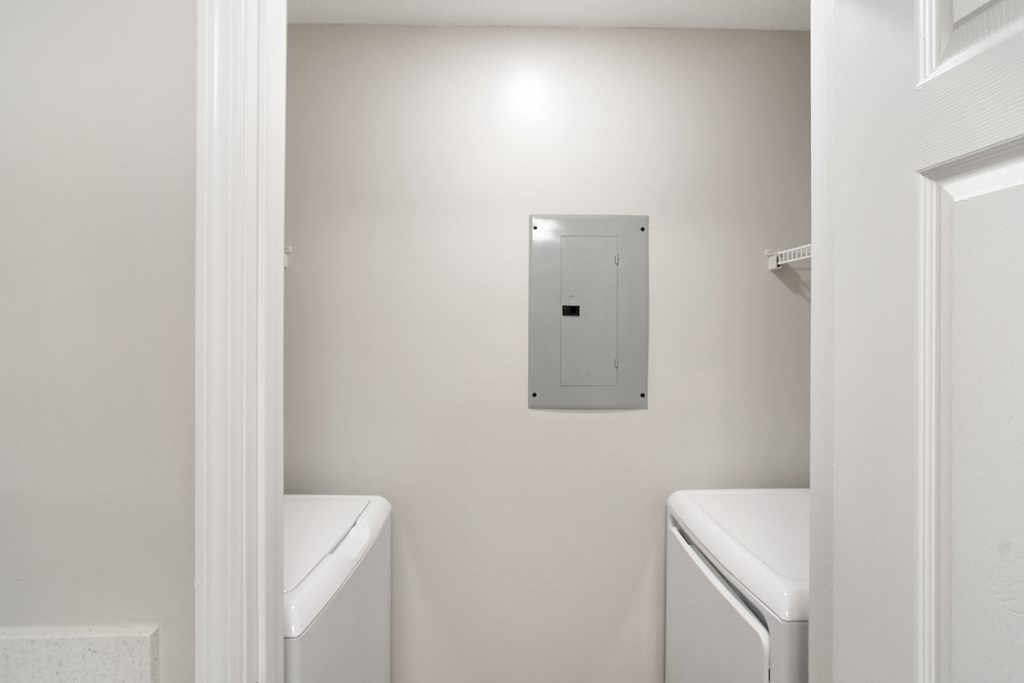 a white laundry room with a white washer and dryer at The Woodlands Apartment Homes, Meridian, MS, 39301