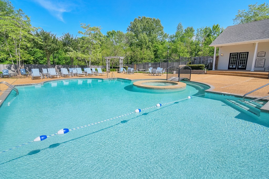 a large pool with chairs and a house in the background at Reserve of Jackson Apartment Homes, Jackson, Mississippi