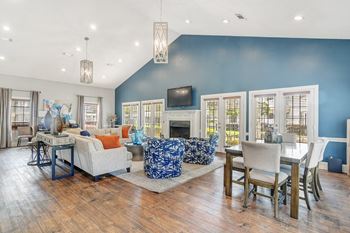 a living room and dining room with blue walls and a fireplace at Reserve of Jackson Apartment Homes, Jackson, MS