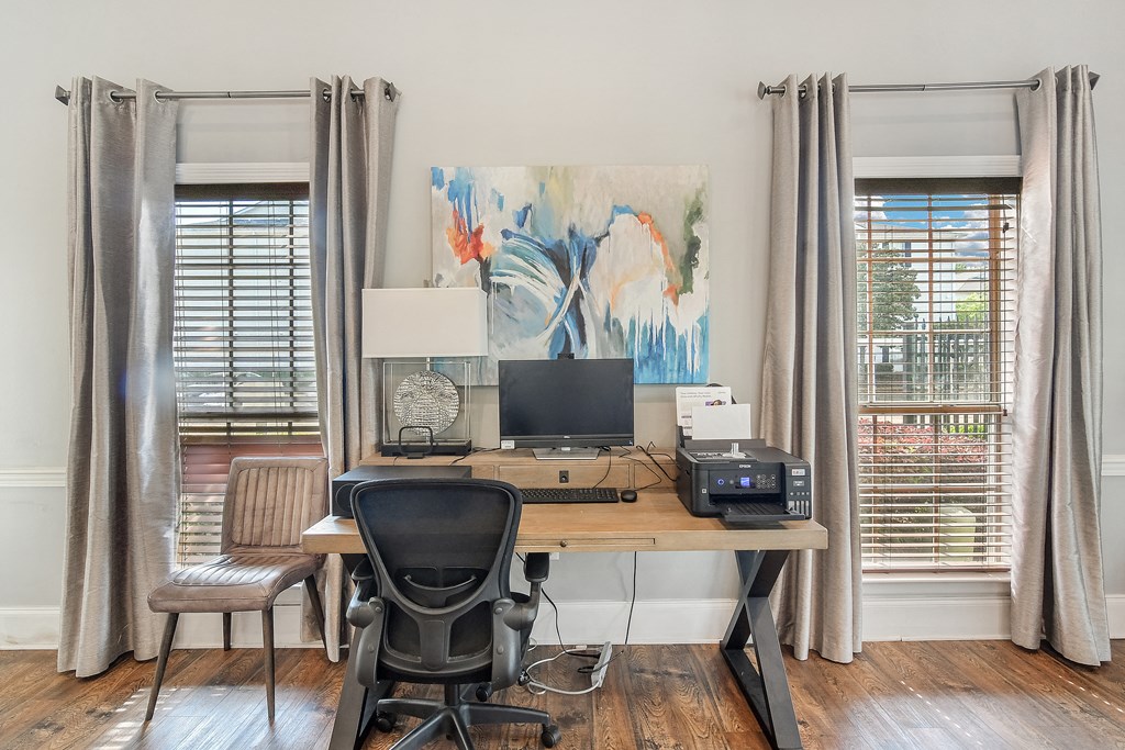 a home office with two windows and a desk with a computer at Reserve of Jackson Apartment Homes, Jackson