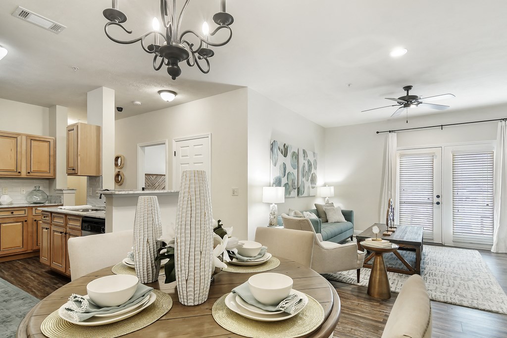 an open living room and kitchen with a dining room table at Charleston Apartment Homes, Mobile, Alabama
