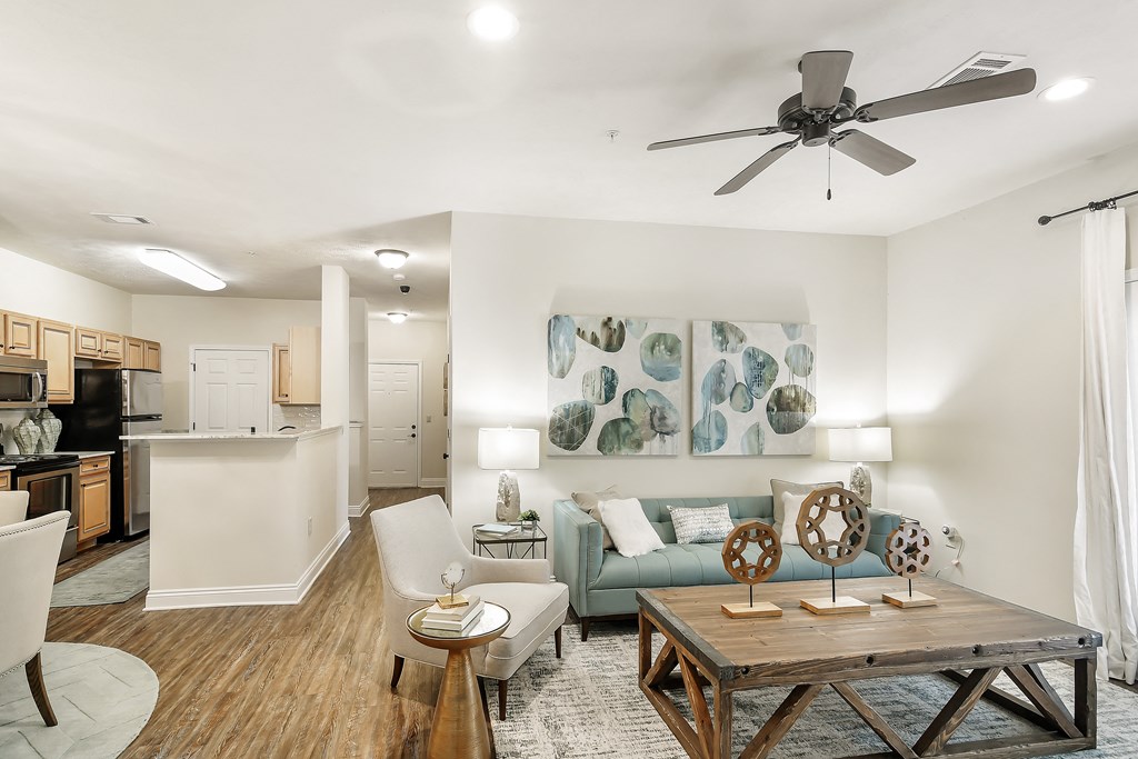 an open living room and kitchen with a ceiling fan at Charleston Apartment Homes, Alabama 36695